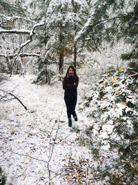 Full length of woman standing on tree trunk
