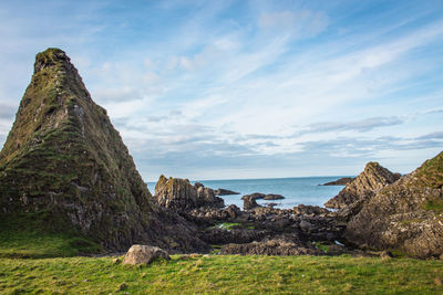 Scenic view of rock formation by sea against sky