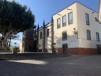 Street by buildings against clear sky