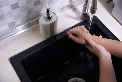 High angle shot of an unrecognizable woman washing her hands , hygiene starts with the hands