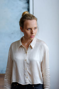 Portrait of woman standing against wall