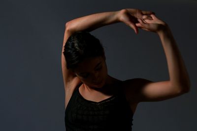 Young woman standing against gray background