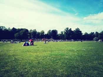 People relaxing on grassy field