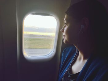 Portrait of woman looking through airplane window