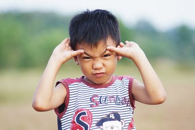 Portrait of cute boy making face outdoors