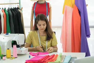 Mid adult woman looking at camera while sitting on table