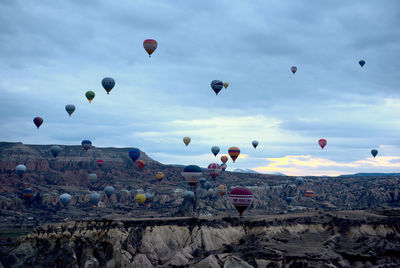 Hot air balloons flying over landscape against sky