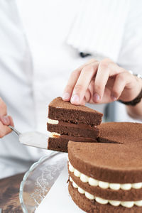 Close-up of hand holding chocolate cake