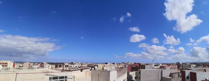 Panoramic view of buildings against blue sky