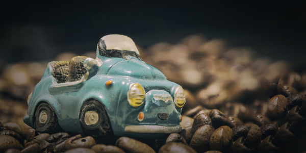 Close-up of toy car on roasted coffee beans