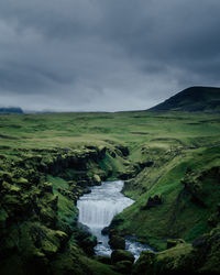 Scenic view of waterfall against sky