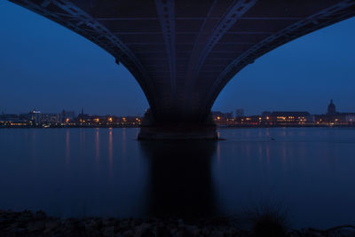 View of bridge over river at night