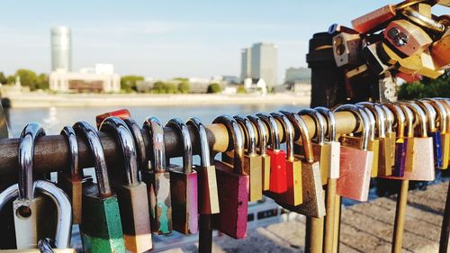 Close-up of love locks hanging on railing in city