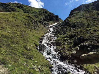 Scenic view of waterfall against sky