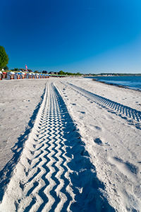 Scenic view of beach against clear blue sky