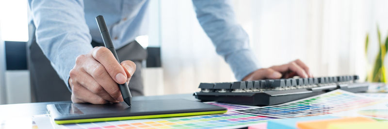 Midsection of man working on table