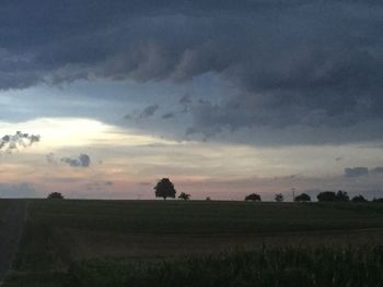 Scenic view of agricultural field against dramatic sky