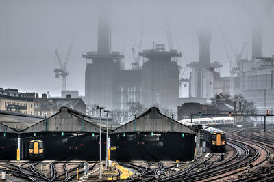 Train on railroad tracks in city against sky