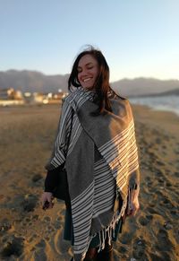 Woman in shawl while standing on beach