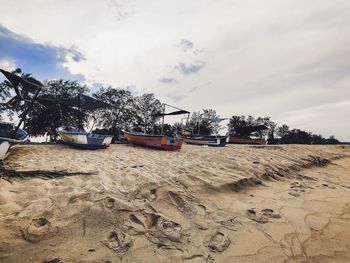 View of fishing boat on beach against sky