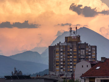 Buildings in city against sky at sunset