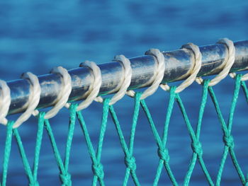 Close-up of rope tied on railing against river