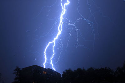 Low angle view of lightning against sky at night