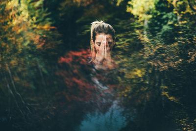 Rear view of woman standing in forest