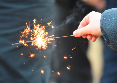 Cropped hand of child holding sparkler