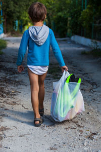 Rear view of woman standing in dirt road