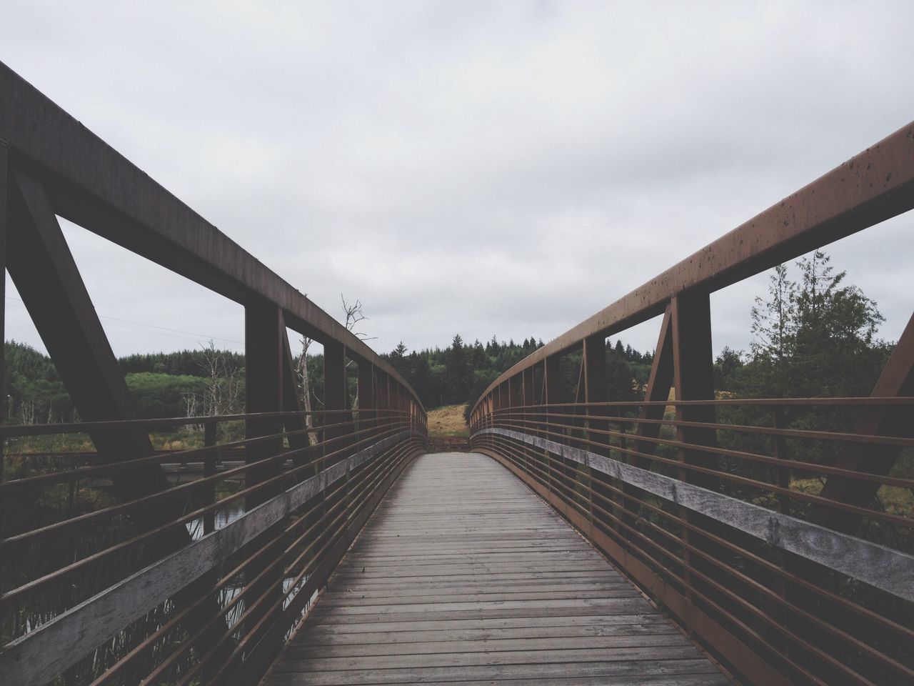 bridge - man made structure, connection, the way forward, built structure, architecture, railing, sky, footbridge, bridge, diminishing perspective, vanishing point, engineering, transportation, cloud - sky, long, wood - material, day, boardwalk, outdoors, cloud