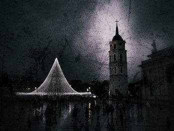 Illuminated clock tower against sky at night