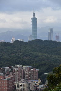 Buildings in city against cloudy sky