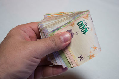 Close-up of hand holding text against white background