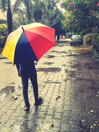 Full length of woman with umbrella walking in rain