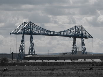 Low angle view of bridge against cloudy sky