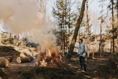 Man burning branches in forest