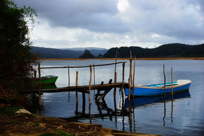 Scenic view of lake and mountains against cloudy sky