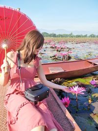 Beautiful woman sitting in gondola at lake