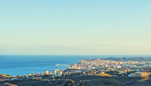 High angle view of townscape by sea against clear sky