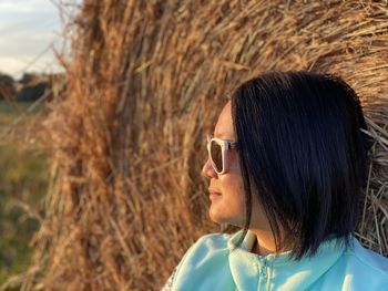 Close-up of mature woman looking away while standing on field