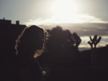 Side view of silhouette woman against sky during sunset
