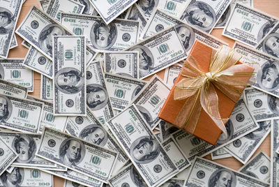 High angle view of gift box with paper currencies on table