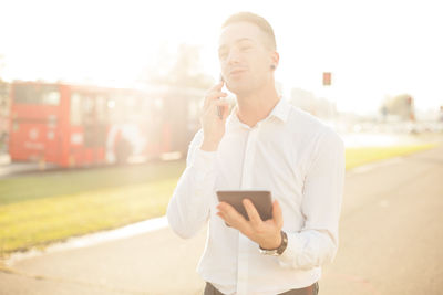 Young man using mobile phone in city