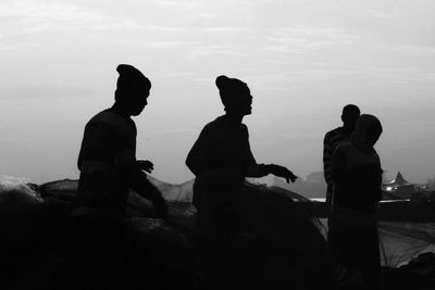 Silhouette people standing against sky