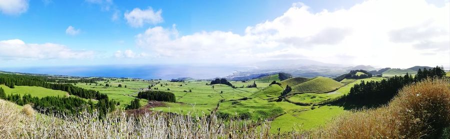 Panoramic view of agricultural field against sky