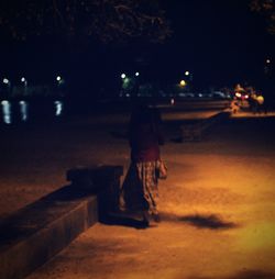 Silhouette man against illuminated sky at night