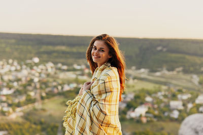 Portrait of smiling young woman standing outdoors