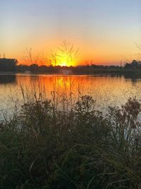 Scenic view of lake against romantic sky at sunset