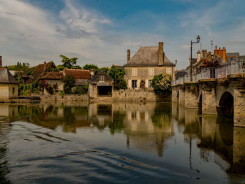 Arch bridge over river against sky